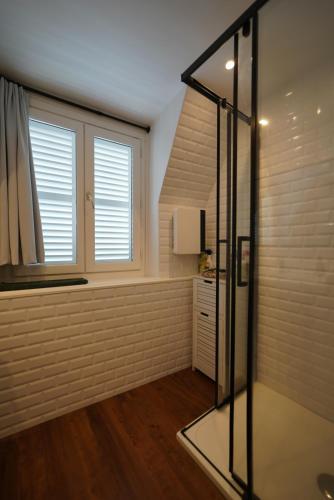 a bathroom with a glass shower and a window at Appartement de Paul in Aurillac