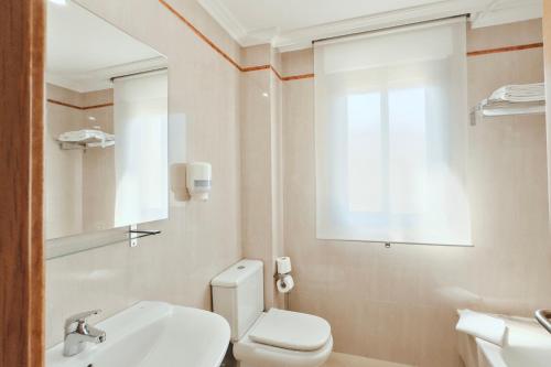 uma casa de banho com um WC, um lavatório e um espelho. em Hotel Mardevela em Sanxenxo