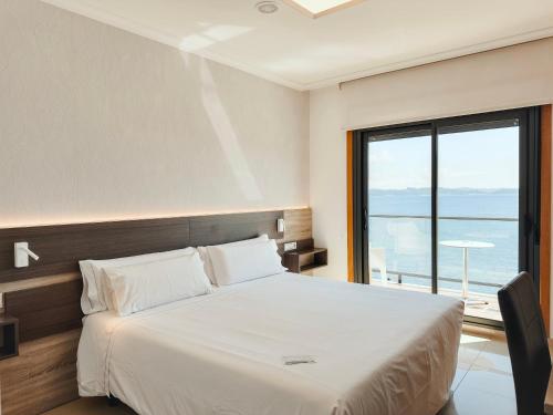 a bedroom with a large bed and a large window at Hotel Mardevela in Sanxenxo