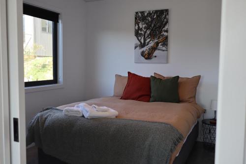 a bed with towels on it in a bedroom at #2 New Modern Cabin with Amazing views over lake in Jindabyne
