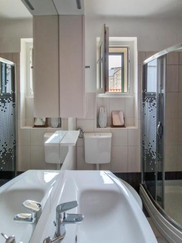 a white bathroom with a sink and a shower at Sea View Apartment No3 Kaštela in Kaštela