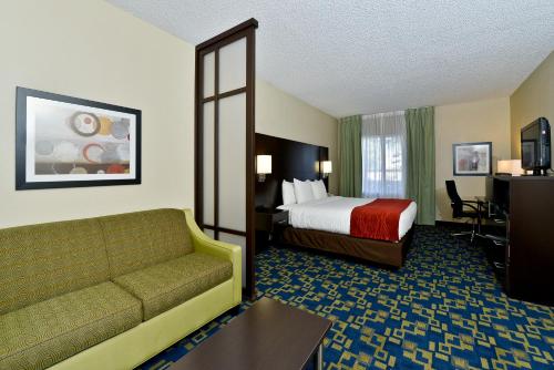 Habitación de hotel con cama y sofá en Comfort Inn & Suites Near Universal Orlando Resort-Convention Ctr en Orlando