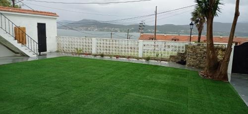a green lawn on a balcony with a white fence at La de Simón in A Guarda