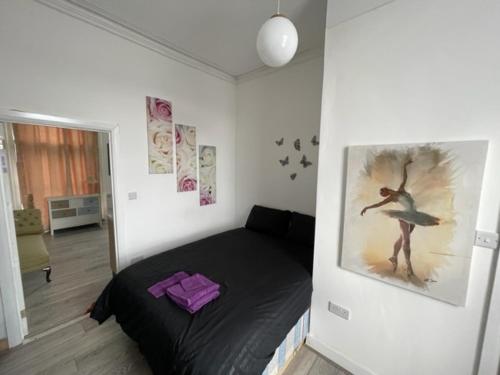 una camera da letto con un letto e un dipinto sul muro di RSB Inn London a Londra