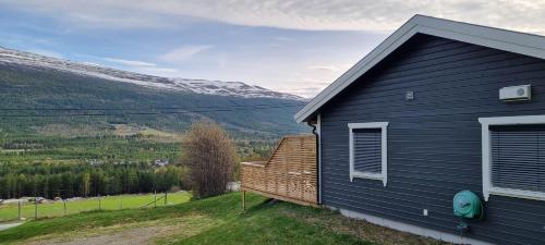 una casa azul con un banco al lado en Hus i flott natur., en Skjåk