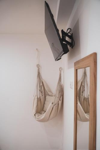 a hammock hanging on a wall next to a mirror at Macramè Room in Bari