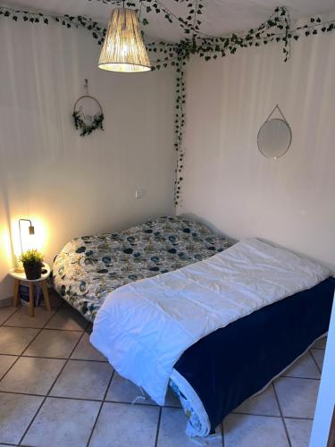 - une chambre avec un lit dans un dortoir doté d'une lampe dans l'établissement Les Gites de Yanaely - Primel, à Juignac