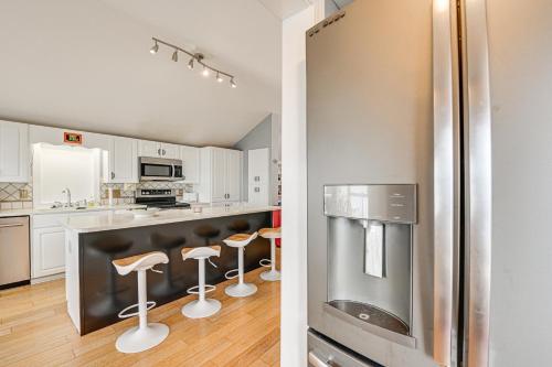 a kitchen with a stainless steel refrigerator and bar stools at Pamlico River House with Private Dock and River View! in Washington