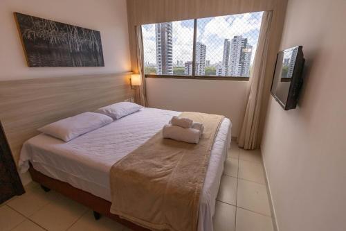 a bedroom with a bed with a teddy bear on it at Hosts BR - Flat Beach Class Boa Viagem (sem taxas) in Recife