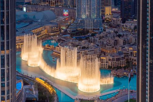 a group of water fountains in a city at night at Elite Royal Apartment - Panoramic with Burj Khalifa & Full Fountain View - High Floor - Patron in Dubai