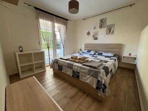 een slaapkamer met een bed en een groot raam bij Sophia's Home near the sea - Olivia Studios in Agia Triada