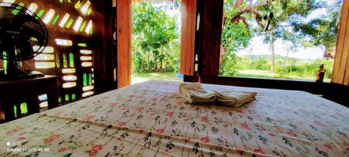 a bed in a room with a large window at Eco Hostel Lunar - Hospedagem Rural - Entrada pelo Sitio da familia Cassiano -Tucumanduba in Soure