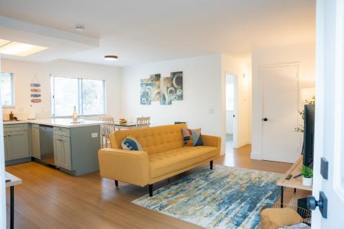 a living room with a couch and a kitchen at 1 Block from Beach - Steps from Restaurants & Shops in Oceanside