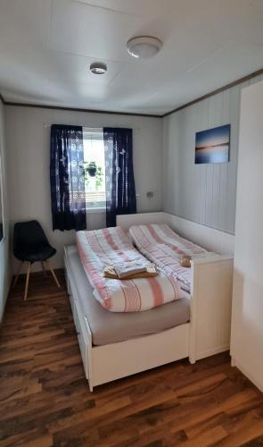 a bedroom with a bed in a room with a chair at Hus i flott natur in Skjåk