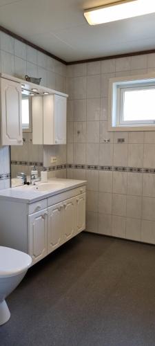 a bathroom with a sink and a toilet and a window at Hus i flott natur in Skjåk