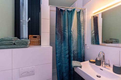 La salle de bains est pourvue d'un lavabo et d'un rideau de douche. dans l'établissement Fancy Loft mit Traumblick, à Leonberg