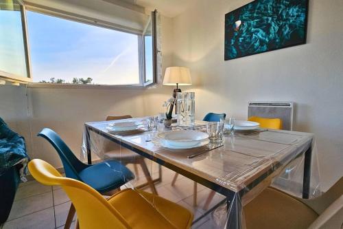 d'une salle à manger avec une table, des chaises et une fenêtre. dans l'établissement L'évasion Carcassonnais avec Terrasse 2 places de Parking privée, à Carcassonne