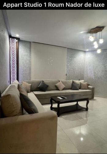 uma sala de estar com um sofá e uma mesa de centro em Apart Nador de Luxe 1 em Nador