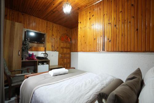 a bedroom with a large bed and wooden walls at OzenTurku Hotel in Pamukkale