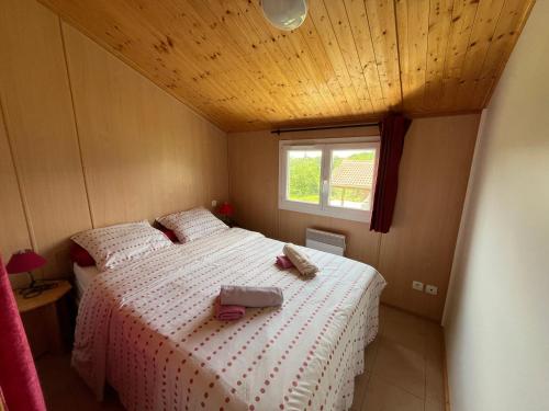 1 dormitorio con 2 camas y ventana en Les Chalets du Piou, en Bussières