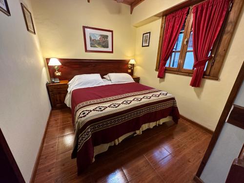 a bedroom with a bed and a window with red curtains at Hosteria Sirenuse in Mar del Plata