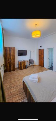 a bedroom with a bed and a desk and a television at Neva Apartments & Rooms in Făgăraş