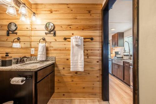 a kitchen with wooden walls and a counter with a sink at Pikes Peak Boutique Retreat! in Woodland Park