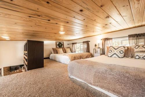 a bedroom with two beds and a wooden ceiling at Pikes Peak Boutique Retreat! in Woodland Park