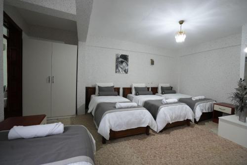 a room with four beds in a room at OzenTurku Hotel in Pamukkale