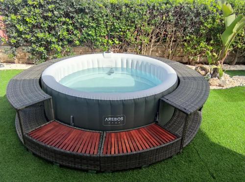 a hot tub in the grass in a yard at Villa Mykonos in Fontane Bianche
