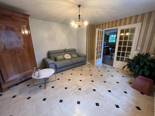 ein Wohnzimmer mit einem Sofa und einem Tisch in der Unterkunft T1 bis 35m2 chez Laurie et Xavier in Mignaloux-Beauvoir