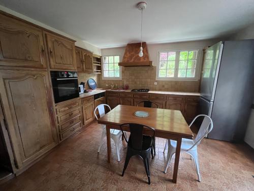 eine Küche mit einem Holztisch und einem Kühlschrank in der Unterkunft T1 bis 35m2 chez Laurie et Xavier in Mignaloux-Beauvoir