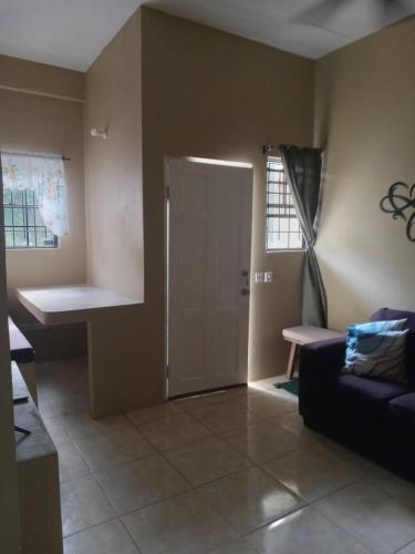 uma sala de estar com uma porta e um sofá em Cozy Apt 15 minutes to Castries Ferry & Rodney Bay em Castries
