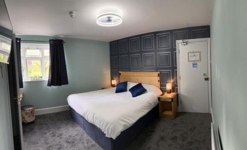 a bedroom with a large bed with a blue headboard at The Crafty Cow in Bristol