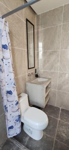 a bathroom with a toilet and a sink and a mirror at Hospedaje Vida in Puerto Escondido