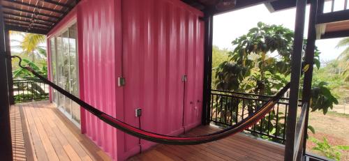 a hammock on a porch of a pink building at Hospedaje Vida in Puerto Escondido