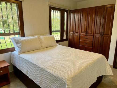 1 dormitorio con cama blanca y ventana en Casa Akuaina en Villa de Leyva