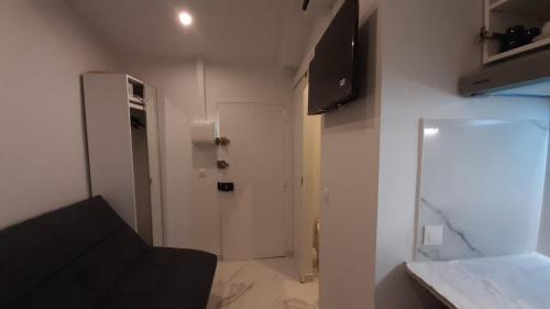 une petite pièce avec un canapé noir et une porte blanche dans l'établissement Winter Palace Beauséjour, à Cannes