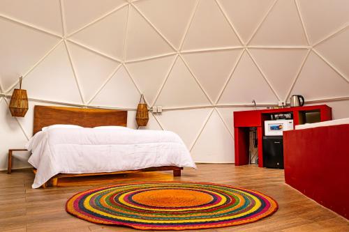 a room with a bed and a rug on the floor at Glamping-Zingo in Santa Ana Jilotzingo