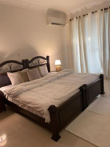 1 cama grande en un dormitorio con ventana grande en The View Apartment, en Dar es Salaam