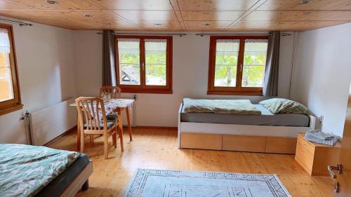 a bedroom with two beds and a table and a chair at Happy Point Apartment in Mellau