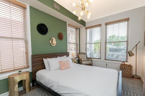 - une chambre avec un lit blanc et des murs verts dans l'établissement 20% OFF I Ybor City Gem I Steps to 7th Ave, à Tampa