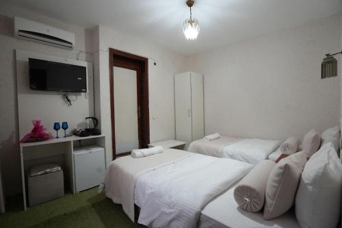 a hotel room with two beds and a flat screen tv at OzenTurku Hotel in Pamukkale
