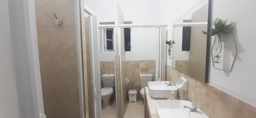 uma casa de banho com 2 WC, um lavatório e um chuveiro em Quinoa Backpackers Hostel em Lima
