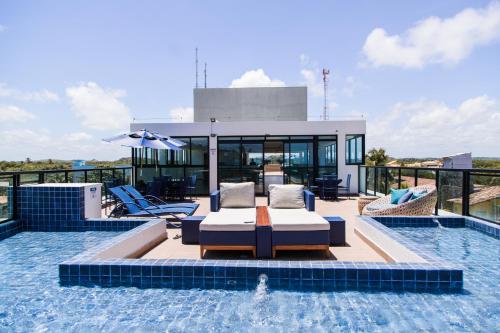 ein Haus mit einem Pool mit einem Tisch und Stühlen in der Unterkunft Maracaipe Estrela Flat110 in Porto De Galinhas