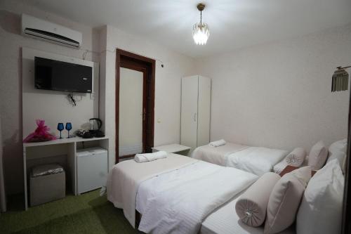 a hotel room with two beds and a flat screen tv at OzenTurku Hotel in Pamukkale