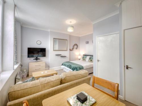 a living room with a couch and a bed at Apartment 4 - Large studio - Sea Front location - Rear views-Free Parking in Paignton
