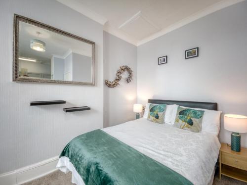 a bedroom with a bed and a mirror on the wall at Apartment 4 - Large studio - Sea Front location - Rear views-Free Parking in Paignton