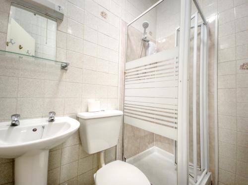 y baño con aseo, lavabo y ducha. en Apartment 4 - Large studio - Sea Front location - Rear views-Free Parking, en Paignton