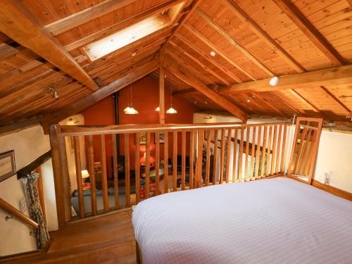 a bedroom with a white bed in a room with wooden ceilings at The Shippon in Conwy